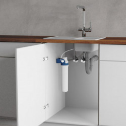 Unterspülenschrank mit installiertem Wasserfilter und sichtbaren Rohranschlüssen