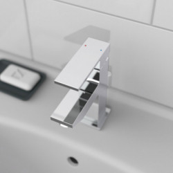 Chromfarbene Einhebelmischbatterie mit rechteckiger Form auf weißem Waschbecken.