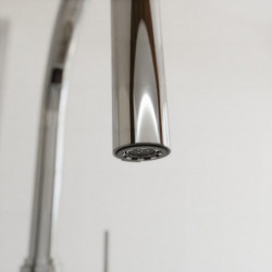 Nahaufnahme eines verchromten Wasserhahnauslaufs mit sichtbarem Strahlregler.