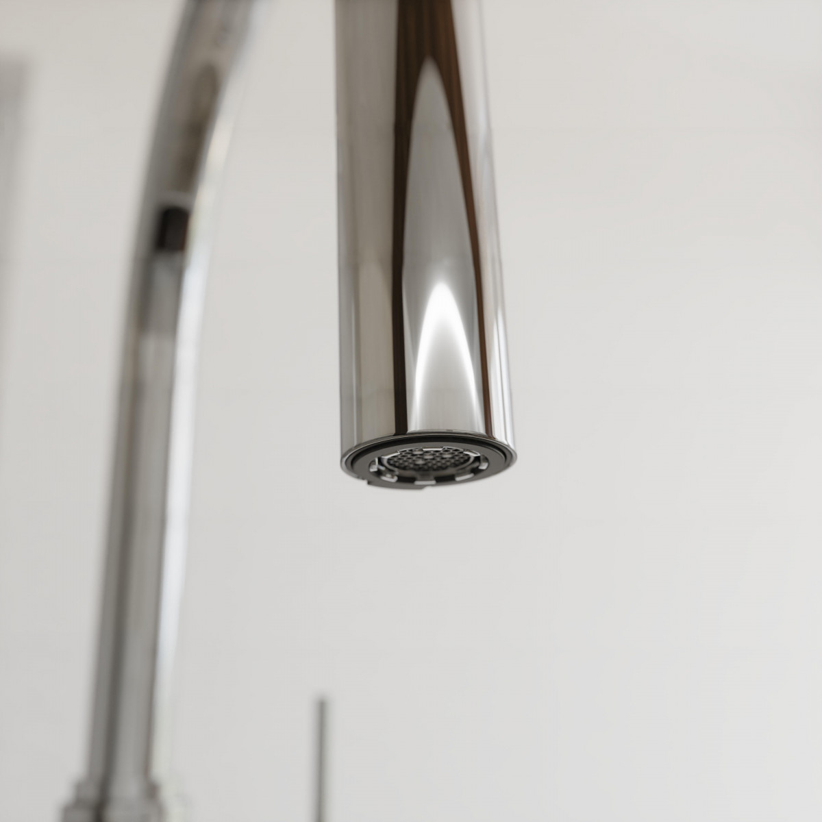 Nahaufnahme eines verchromten Wasserhahnauslaufs mit sichtbarem Strahlregler.