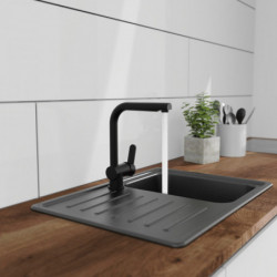 Schwarze Küchenarmatur mit Hebel über Edelstahlspüle mit Abtropffläche.