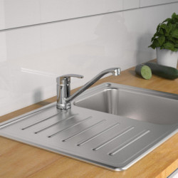 Edelstahlspüle mit Abtropffläche und verchromter Einhebelarmatur auf Holzarbeitsplatte