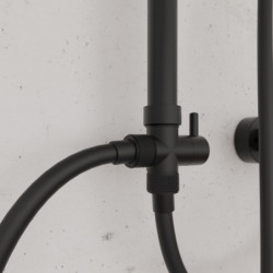 Detail einer schwarzen Duscharmatur mit Rändelgriff und Hebel an heller Wand.