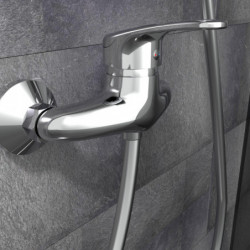 Chrom-Wandarmatur mit Einhebelmischer und Brauseschlauch vor grauer Fliesenwand
