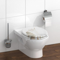 Toilettensitz mit Motiv aus Steinen und Gräsern auf einem weißen WC im Badezimmer.