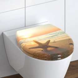 WC-Sitz mit Strandmotiv und Seestern bei Sonnenuntergang auf weißer Toilette