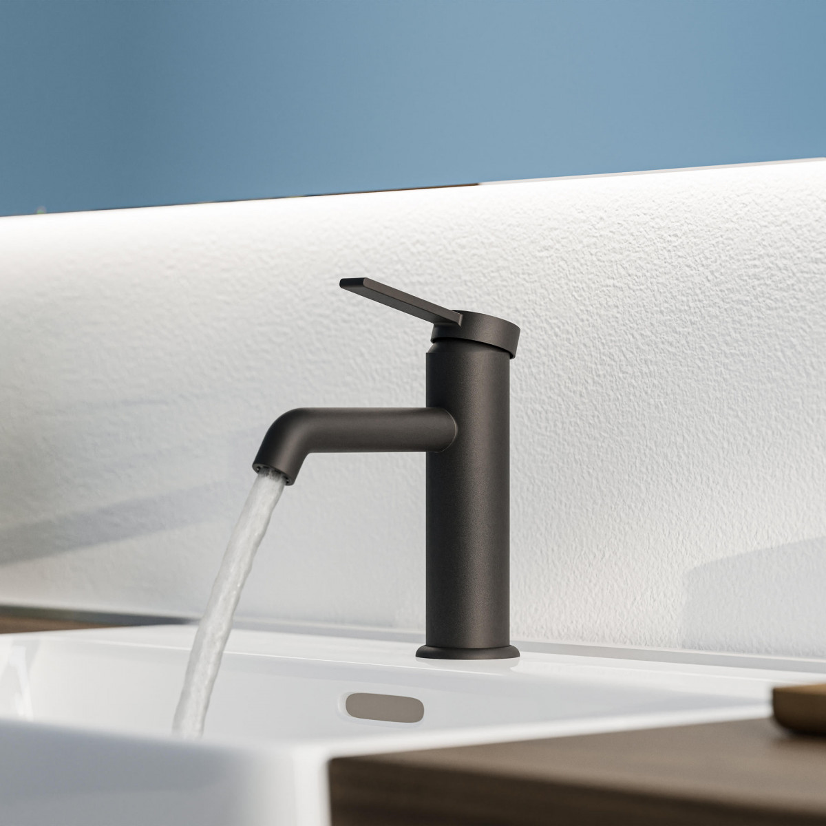 Schwarze Waschtischarmatur mit Hebelgriff, Wasser läuft in weißes Waschbecken.