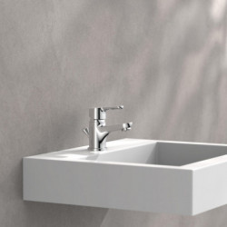 Chromfarbene Einhebel-Waschtischarmatur auf weißem Wandwaschbecken vor grauer Wand.