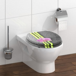Schwarz gesprenkelter WC-Sitz mit grünen Streifen und pinker Orchideenblüte auf weißem WC.
