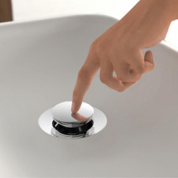 Hand drückt runden verchromten Druckknopf am Waschbeckenabfluss